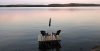 Muskoka chairs sit on a dock looking over Boshkung Lake, in Algonquin Highlands