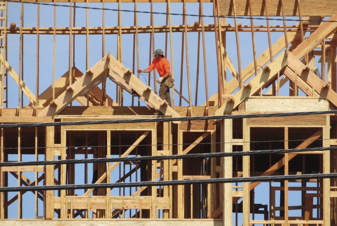 Un ouvrier du bâtiment examine une partie d'un bâtiment en construction